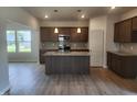 Stylish kitchen with granite countertops, dark wood cabinets, and stainless steel appliances at 89 Grove Township Way, Angier, NC 27501