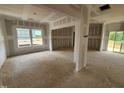 Unfinished living room space with multiple windows, exposed studs, and a support pillar at 89 Grove Township Way, Angier, NC 27501