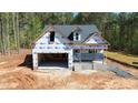 New construction home showing garage, windows and roof with house wrap and unfinished yard at 90 Purslane Dr, Franklinton, NC 27525