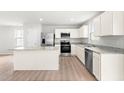 Well-lit kitchen featuring white cabinets, granite countertops, and stainless steel appliances at 107 Port Charlotte Ct, Sanford, NC 27330