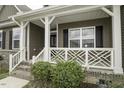 Close up of a cozy front porch with white railings and a meticulously maintained garden at 1108 Agio Ct, Zebulon, NC 27597