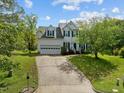 Charming two-story home featuring a two-car garage and a beautifully landscaped front yard with mature trees at 113 Laurel Branch Dr, Cary, NC 27513