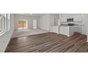 Open-concept living area with modern floors, plush carpeting, and a breakfast bar with a view of the kitchen at 121 Gladstone Loop Dr, Clayton, NC 27520