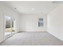 Spacious carpeted bedroom with a sliding glass door and a window bringing in natural light at 125 Gladstone Loop, Clayton, NC 27520