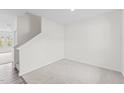 Bright living room features neutral carpet and an open staircase at 129 Gladstone Loop, Clayton, NC 27520