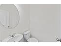 Clean powder room featuring a modern round mirror and commode at 129 Gladstone Loop, Clayton, NC 27520