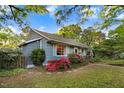 Inviting home exterior showcasing beautiful flowering bushes, well-maintained lawn, and lush green trees at 1518 Echo Rd, Durham, NC 27707
