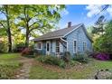 Quaint single-story home showcasing a welcoming front porch, landscaped garden, and a well-maintained lawn at 1518 Echo Rd, Durham, NC 27707