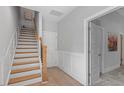 Bright hallway with hardwood floors, wooden stairs, and white wainscoting for a classic look at 1601 Bowery Dr, Raleigh, NC 27607