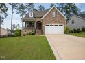 Charming two-story home featuring a stone facade, two-car garage, and manicured lawn at 171 School Side Dr, Spring Lake, NC 28390