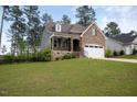 Charming two-story home featuring a stone facade, two-car garage, and manicured lawn at 171 School Side Dr, Spring Lake, NC 28390