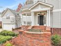 Charming front entrance with brick steps and railing, as well as a classic black front door at 206 Arbor Dr, Elon, NC 27244