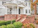 Inviting front porch with brick steps and railing offers a cozy entrance to the home at 206 Arbor Dr, Elon, NC 27244