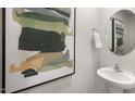 Stylish powder room with modern fixtures, artistic painting, and round mirror detail at 2156 Monk Dr, Haw River, NC 27258