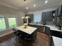 Bright kitchen featuring a center island with seating, stainless steel appliances, and gray cabinetry at 223 E Nash St, Spring Hope, NC 27882