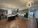 Modern kitchen with gray cabinets, stainless steel appliances, island with seating, and beautiful hardwood floors at 223 E Nash St, Spring Hope, NC 27882