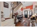 Elegant foyer with staircase, chandelier, vintage sewing machine and Persian rug accenting the hardwood floors at 308 S Pearl St, Rocky Mount, NC 27804