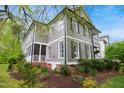 Lovely two-story home with a screened porch, lush landscaping, and classic architectural details at 3332 Cheswick Dr, Raleigh, NC 27609
