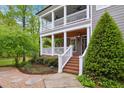 Inviting front entrance with a covered porch, brick stairs, and beautifully landscaped walkway at 3332 Cheswick Dr, Raleigh, NC 27609