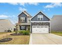 Inviting two-story home with a stone facade, attached two-car garage, and manicured landscaping for great curb appeal at 361 W Copenhaver Dr, Clayton, NC 27527