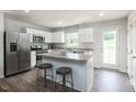 Bright kitchen features stainless steel appliances, a center island, and white cabinetry at 363 Tormore Dr, Sanford, NC 27330