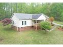 The house has a side porch and mature trees around the yard with a partial brick foundation at 3954 Piney Grove Church Rd, Siler City, NC 27344