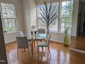 Bright dining area with hardwood floors, large windows, and modern decor create an inviting atmosphere for meals at 4502 Pale Moss Dr. Dr, Raleigh, NC 27606