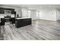 Bright open-concept kitchen and living space with stainless steel appliances and grey flooring at 58 Furley St, Sanford, NC 27330