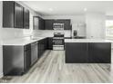 Modern kitchen with stainless appliances, an island, and dark cabinetry with white countertops at 66 Furley St, Sanford, NC 27330