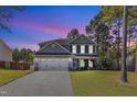 Beautiful two-story home with a two-car garage, well-maintained lawn, and inviting front porch at dusk at 78 Parkview Ln, Lillington, NC 27546