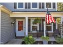 Inviting front porch features a bench, American flag, and stylish decor, perfect for relaxing outdoors at 78 Parkview Ln, Lillington, NC 27546