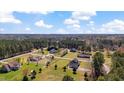 Picturesque aerial shot of houses nestled in a lush, green neighborhood with many mature trees and blue skies at 80 Greta Ln, Henderson, NC 27537