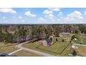 Aerial view of estate home with expansive grassy yard with surrounding mature trees in a private, secluded setting at 80 Greta Ln, Henderson, NC 27537