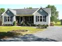 Well-maintained home featuring tidy landscaping, complemented by a gravel driveway at 860 Bear Rd, Benson, NC 27504