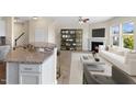 Open-concept living room flows from kitchen with fireplace, modern shelving, and sleek furnishings at 1019 Thoughtful Spot Ln, Durham, NC 27703