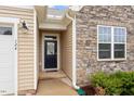 Close-up of the front door, showcasing the stone and vinyl siding and manicured landscaping at 124 Alta Crest Ln, Garner, NC 27529