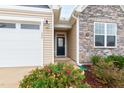 Close up of the front entrance with a storm door and beautiful landscaping with colorful flowers at 124 Alta Crest Ln, Garner, NC 27529