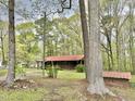 View of a charming brick home with a covered porch and red metal roof at 1622 N Carolina 98 Hwy W, Louisburg, NC 27549