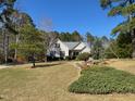 Well-manicured front yard with mature trees and landscaping around a charming home at 20 Willows Den Ct, Youngsville, NC 27596