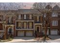 Charming three-story townhome with brick facade, attached garages, and front balcony at dusk at 222 Lions Gate Dr, Cary, NC 27518