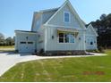 Home exterior showcasing an attached garage, complemented by a well-maintained yard and landscaping at 2617 Packhouse Rd, Zebulon, NC 27597
