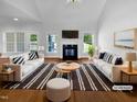 Bright living room featuring vaulted ceilings, fireplace, hardwood floors and a large window for natural light at 30 Alvis Ct, Fuquay Varina, NC 27526