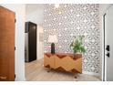 Modern entryway featuring a striking geometric wallpaper, stylish sideboard, and minimalist decor, creates a memorable first impression at 3016 Sylvania Dr, Raleigh, NC 27607
