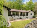 Charming home featuring a brick pathway, white painted brick, a covered porch and professional landscaping at 3518 Travis Ct, Chapel Hill, NC 27516