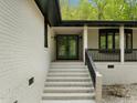 Inviting front entry with elegant double doors, classic stairs and decorative wrought iron accents at 3518 Travis Ct, Chapel Hill, NC 27516