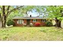 Charming brick home with mature trees, flowering shrubs, and a welcoming front entrance at 428 Mitchell Ave, Franklinton, NC 27525