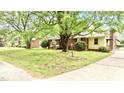 Charming brick home with mature trees, flowering shrubs, and a welcoming front entrance at 428 Mitchell Ave, Franklinton, NC 27525