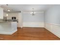 Inviting dining area with hardwood floors, chandelier lighting, and wainscoting, connecting to the kitchen at 501 Finsbury Street # 103, Durham, NC 27703