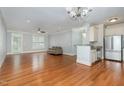 Bright, open living room with hardwood floors, ceiling fan, and a view to the kitchen and outdoor balcony at 501 Finsbury Street # 103, Durham, NC 27703