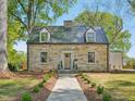 Beautiful stone house with dormer windows and mature trees in a landscaped front yard at 511 Circle Dr, Burlington, NC 27215
